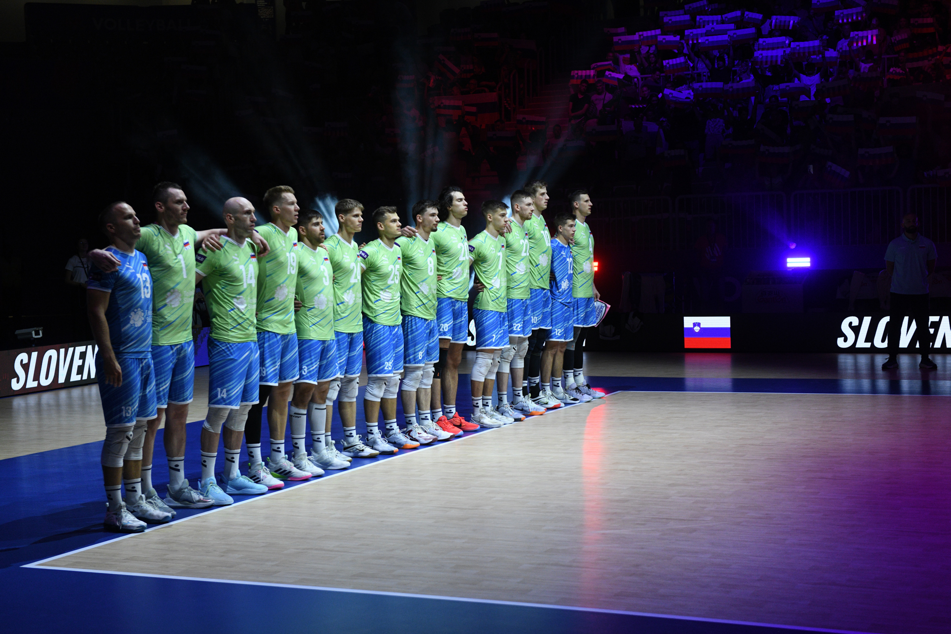 Slovenska moška odbojkarska reprezentanca v zelenih in modrih dresih med postavitvijo ekipe pred začetkom tekme